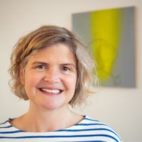 Porträtfoto von Barbara Tamm, einer freundlich lächelnden Osteopathin in einem blau-weiß gestreiften Shirt vor hellem Hintergrund. Neben dem Bild steht der Willkommenstext der Praxis.