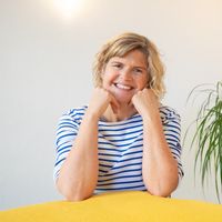 Porträtfoto von Barbara Tamm, einer freundlich lächelnden Osteopathin in einem blau-weiß gestreiften Shirt vor hellem Hintergrund. Neben dem Bild steht der Willkommenstext der Praxis.