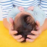 Porträtfoto von Barbara Tamm, einer freundlich lächelnden Osteopathin in einem blau-weiß gestreiften Shirt vor hellem Hintergrund. Neben dem Bild steht der Willkommenstext der Praxis.